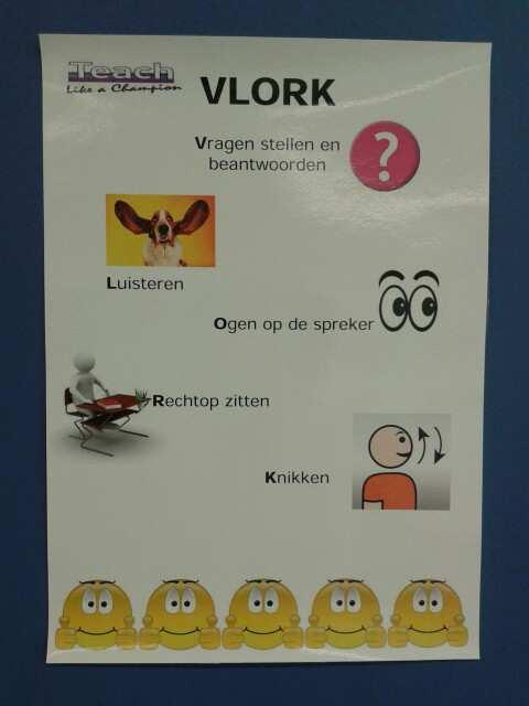 In hoog tempo gaat de juf de leerlingen langs. Zij neemt woorden met ze door die ze de vorige les geleerd hebben. Noemt namen van kinderen die hun vinger opsteken, maar ook van wie dat niet heeft.