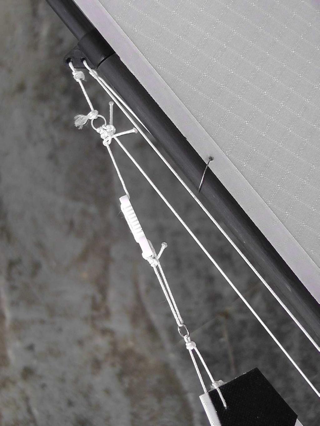 Knoop een stuk draad, waar een lijnspanner overheen geschoven is, vast aan de ring die op ongeveer 10 van de top van de mast zich moet bevinden.