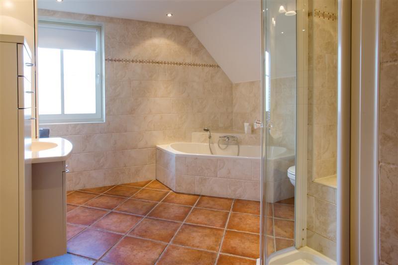 Luxe en geheel betegelde badkamer in lichte kleurstelling en het