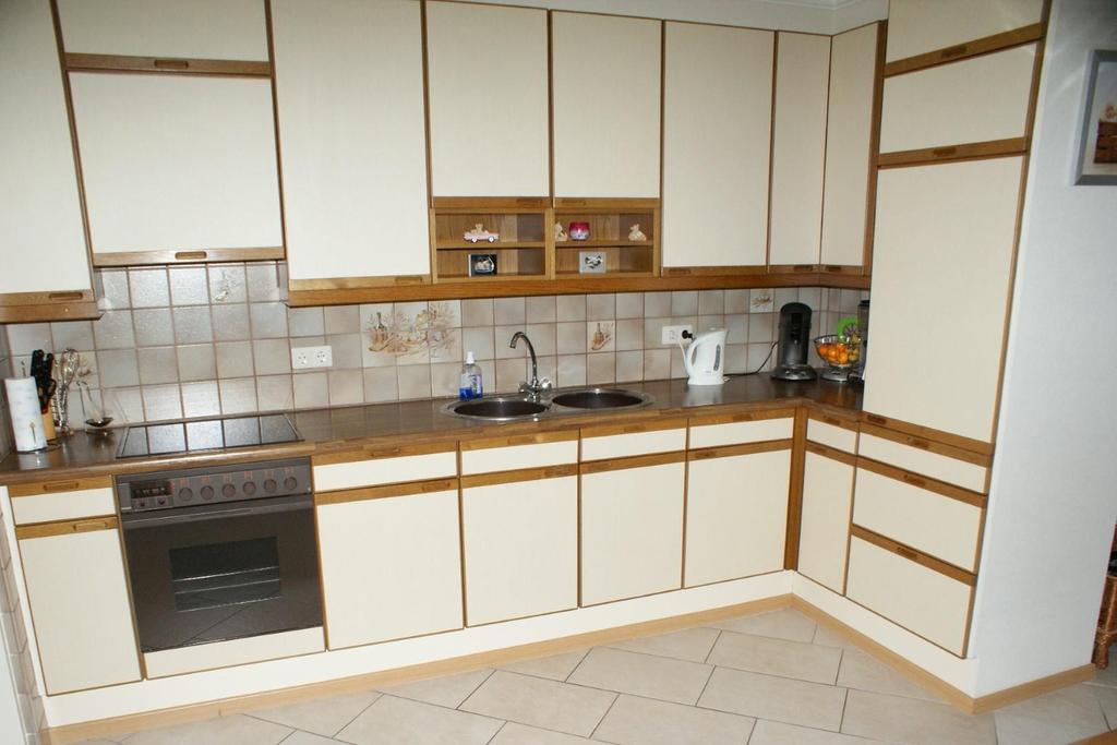 De open keuken in L-opstelling is uitgerust met een dubbele spoelbak, kookplaat, oven, afzuigkap en