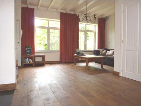 ERNHOUTW De L-vormige woonkamer is voorzien van een eiken houten vloer en de wanden zijn voorzien van stucwerk.
