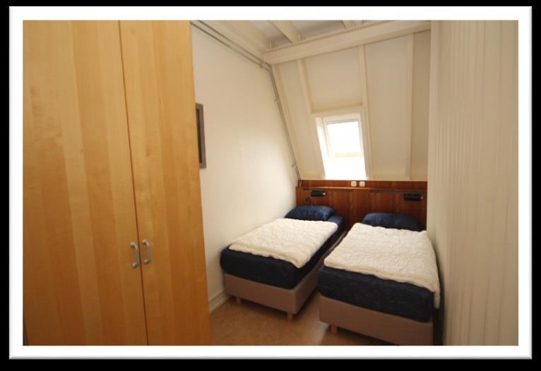 De 2-persoons slaapkamer is voorzien van een harmonicadeur, boxspringbedden, velux dakraam en een ruime kledingkast.