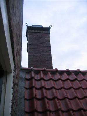 B) Dakbedekkingen Het zadeldak is voorzien van rode verbeterde Hollandse dakpannen. De kwaliteit is nog goed. De nokvorsten zijn enigszins los gekrompen.