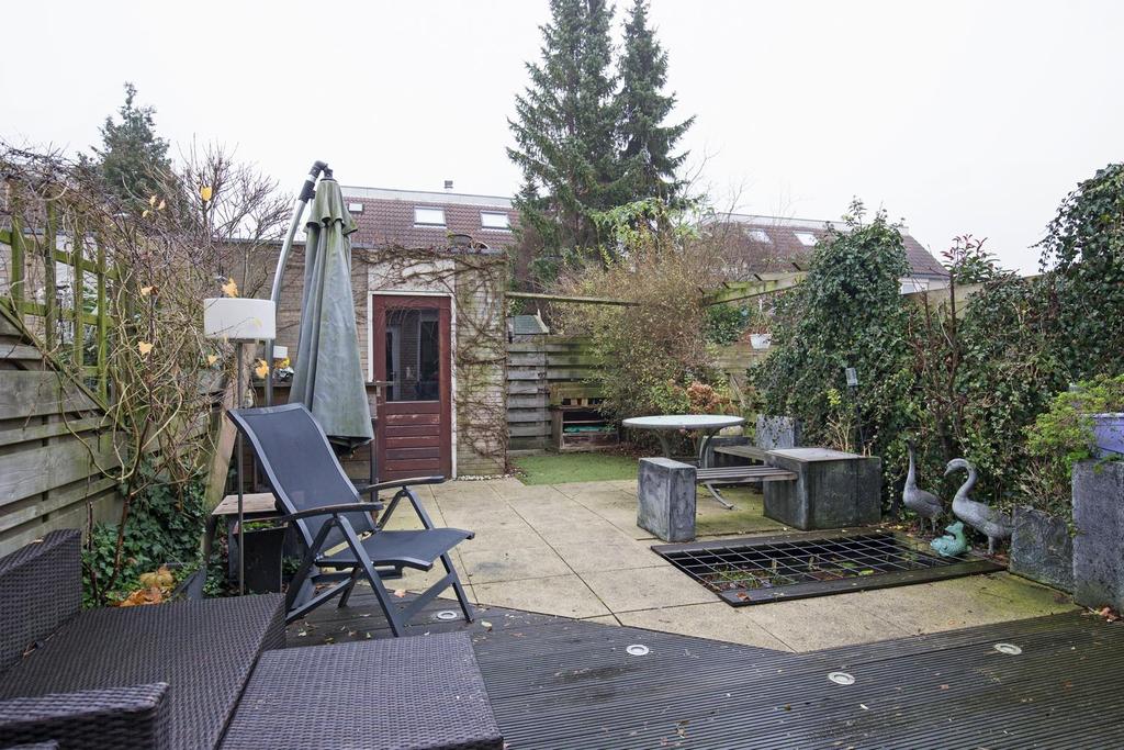 TUIN In 2012 is de op het noordoosten gelegen achtertuin verzorgd aangelegd met een houten terras voorzien van grondspots, bestrating, een vijver en vaste beplanting.