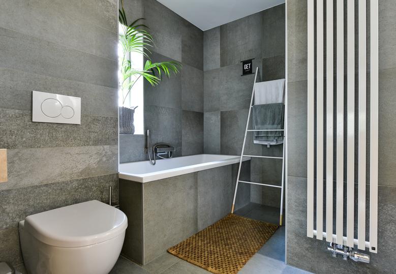 De lue badkamer (2016) is tot het plafond betegeld, met ligbad, zijraam,