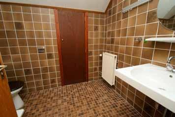 Foto links: De badkamer op de eerste verdieping is voorzien van douche, toilet en wastafel.