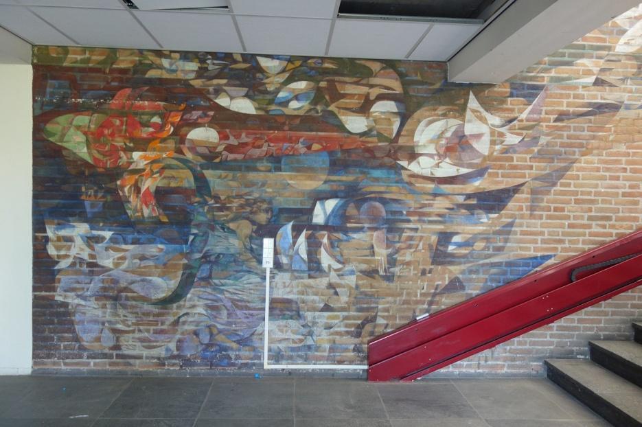 Verslag bezoek van der Puttlyceum 2 De kleurige wandschildering op de muur bij een trap is van Albert (Albertus Antonius Johannes) Troost (1924-2010) Van de muurschildering uit 1964 direct op