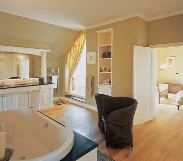 Deze zeer ruime badkamer die rechtstreeks uitgeeft op de slaapkamer is met veel aandacht voor esthetische vormgeving ontworpen.