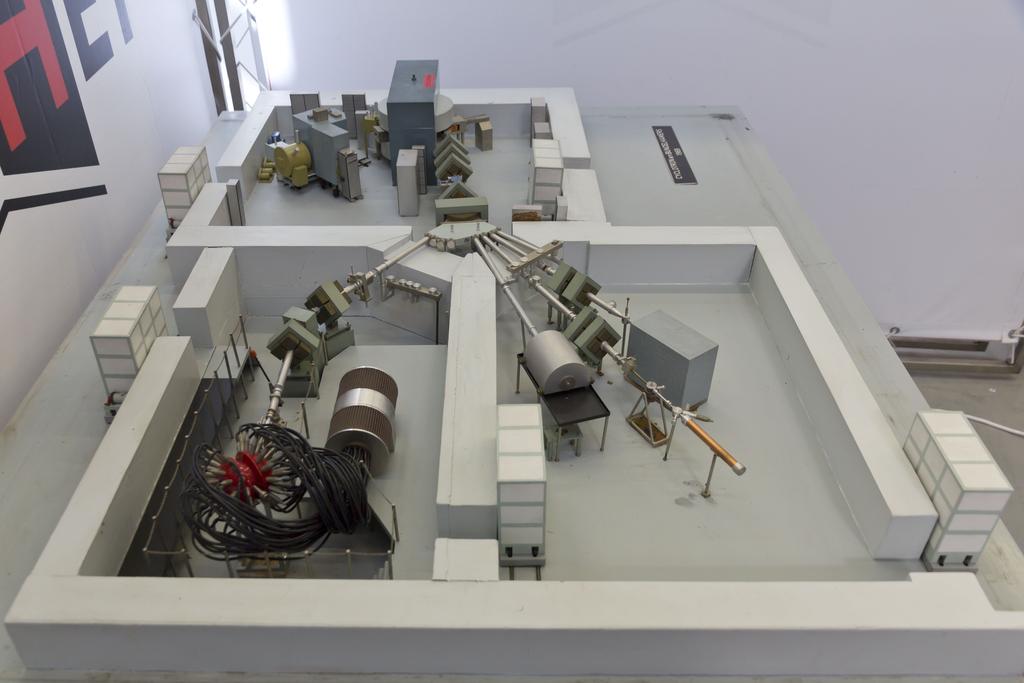 4 2 3 3 1 5 2 3 2 Maquette (1967) van het cyclotron met het externe bundelsysteem dat twee experimentele hallen bestrijkt, voor straling afgeschermd door betonnen wanden: de hal rechts voor