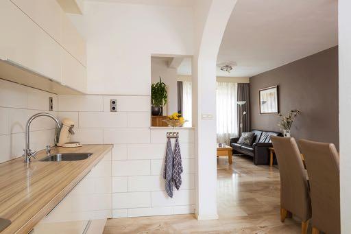 De moderne open keuken is bereikbaar vanuit de woonkamer en loopt door in de