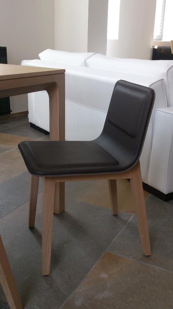 Chaise contemporaine en chêne massif et assise en cuir brun, le dos est fini d un feutre de laine naturel