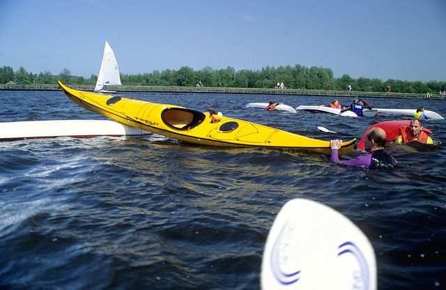 Om weer in de kano s te kunnen komen wordt de stevigste kano als centraal punt gebruikt; een aantal vaarders houdt deze boot vast.