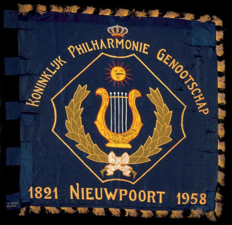 Nr. 66 1958 Koninklijke Philharmonie Nieuwpoort zijde borduurwerk, applicatie meerkleurig, zwart/geel/rode franjes 120 x 120 cm lussen aan de broekzijde 8,5 x 11 cm beschadigd, schifting van de stof,