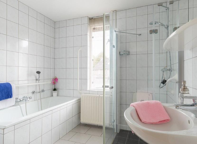 Badkamer Keurige geheel betegelde badkamer met een ligbad met