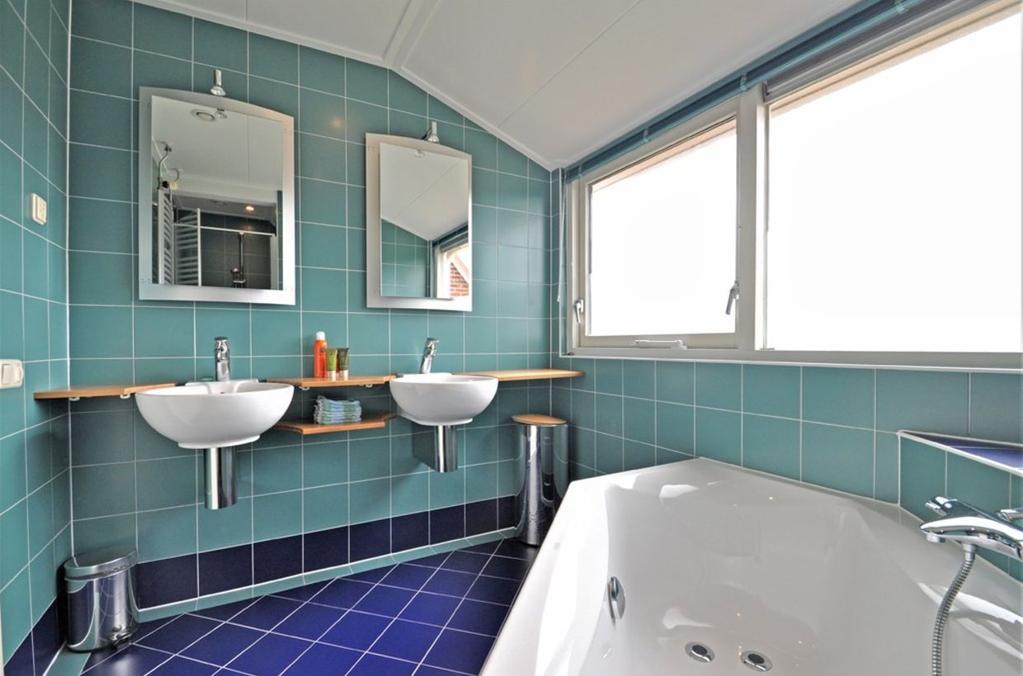 Ligging en indeling De badkamer is voorzien van vloerverwarming en ingedeeld met bad (met whirlpool), 2 wastafels en vergroot met een aparte douchecel.
