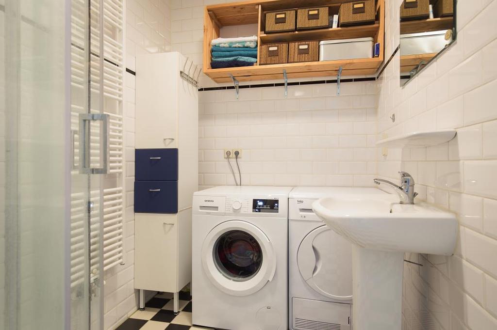 kraan vernieuwd), een handdoekradiator en een wastafel met planchet en spiegel. Het sanitair is in het wit uitgevoerd.