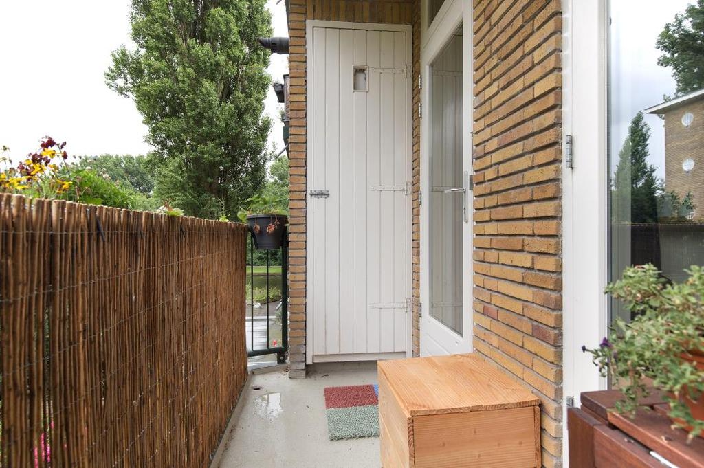 Het balkon strekt zich uit over de gehele breedte van de woning en is te betreden vanuit de keuken en slaapkamer 1.