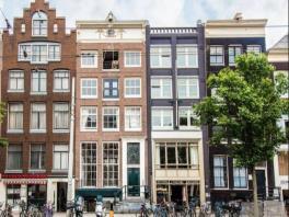 In het centrum van Amsterdam komt deze mooie belegging te koop: de bedrijfsruimte op de begane grond en afzonderlijke bovenwoning op de 1e etage, staande en gelegen aan de Nieuwezijds Voorburgwal en