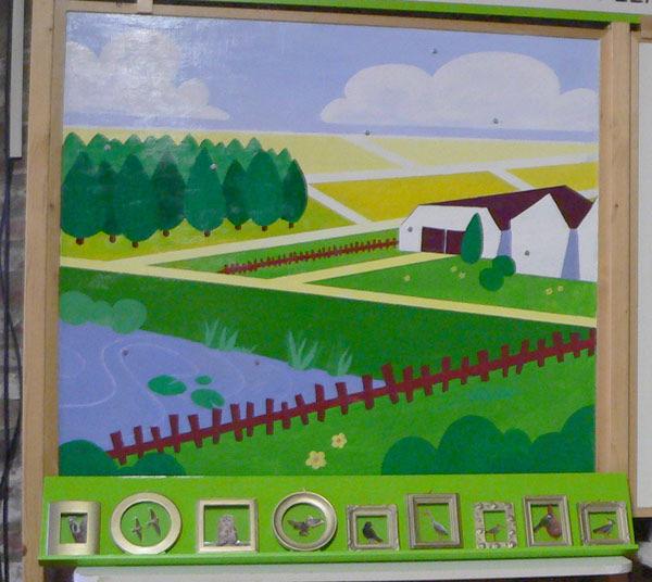 Kijk met de kinderen naar de schildering op het linkerbord. Wat is hier te zien? Een huis met tuin, weilanden, bos, water. Bos Kunnen hier ook vogels leven? Natuurlijk.