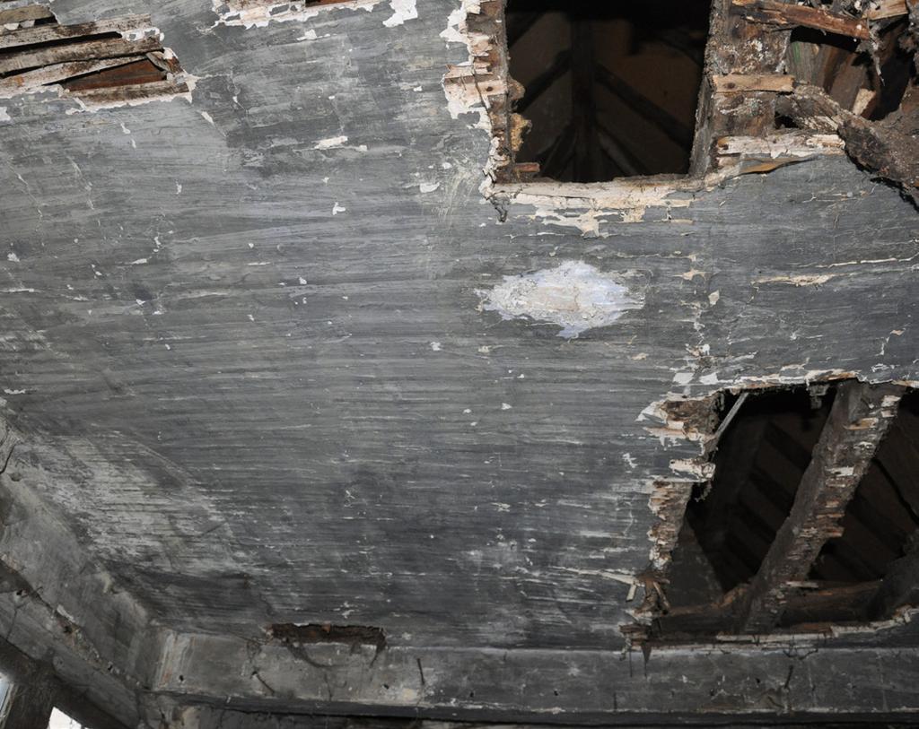 De nokpannen zijn in goede staat, maar hun onderlinge cementering is gebarsten en uitgevallen. De aansluiting tussen het dak van de achterbouw met de noordelijke muur werd eveneens gecementeerd.