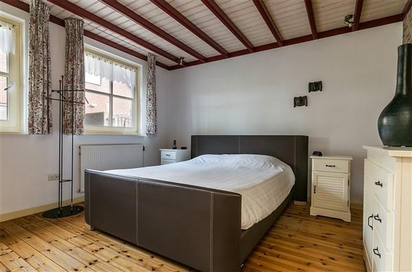 De (ouder)slaapkamer op de begane grond is voorzien van een houten vloer, de wanden zijn deels uitgevoerd in stucwerk en deels