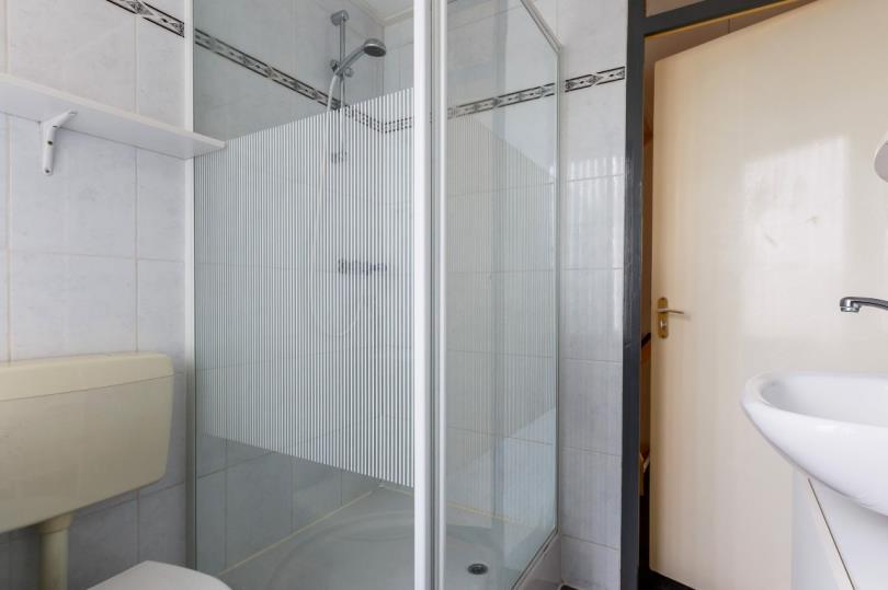 De badkamer: De nette badkamer is volledig betegeld in neutrale