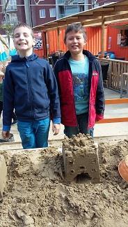 Wij hebben met het zand een vierkantige kasteel met brug gebouwd.