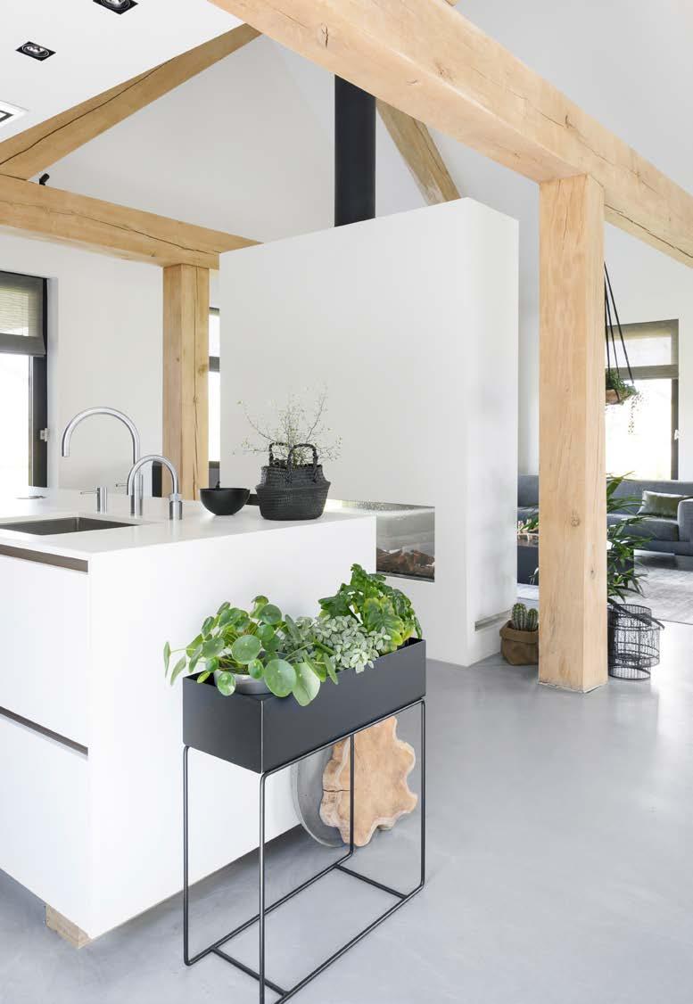 Tussen de keuken en de zithoek is een doorkijkgashaard geïnstalleerd door Van Manen Haarden & Kachels in Barneveld.