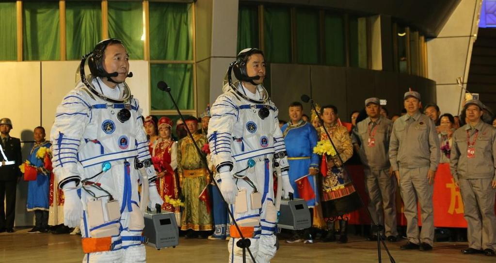 Jing Haipeng (l) en en Chen Dong (r) in hun ruimtepakken kort voor hun vertrek naar het lanceerplatform.