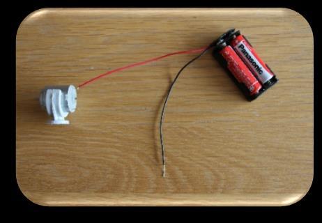 Hoe maak je een robot? Duw het klemmetje over de motor Verbind de rode draad van de batterijhouder met de motor.