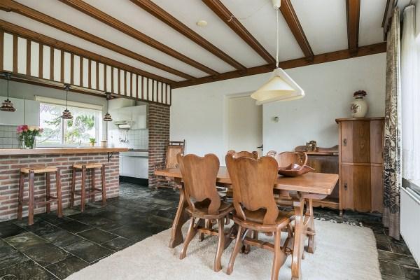De keuken is afgewerkt met een leistenen vloer, deels betegelde wanden en een houten balken plafond.