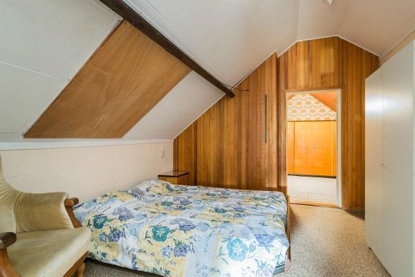 (Slaap)kamer V is voorzien van vloerbedekking, deels metselwerk en deels betimmerde wanden en een gipsplaten plafond.