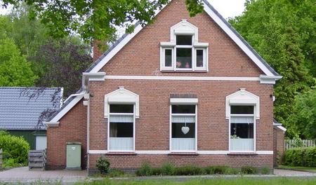 Markant woonhuis in verzorgde, expressionistische architectuur, invloed Amsterdamse Schoolstijl. Voormalige directeurswoning. Bijbehorende erfafscheiding.