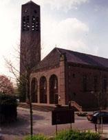 Tegen de zijmuur van de kerk staat het oorlogsmonument. Een uit bakstenen opgetrokken gedenkmuur met acht kruisen van witte natuursteen.