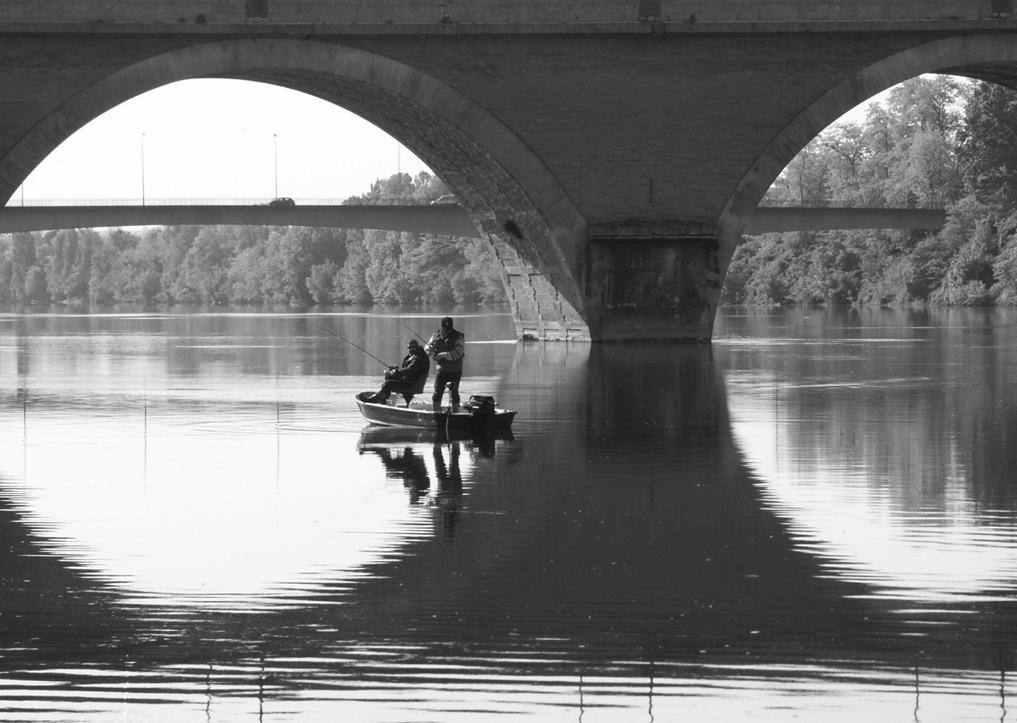 Sportvisserij is wereldwijds foto: Vissen in de schaduw van de brug bij het Franse Bergerac.