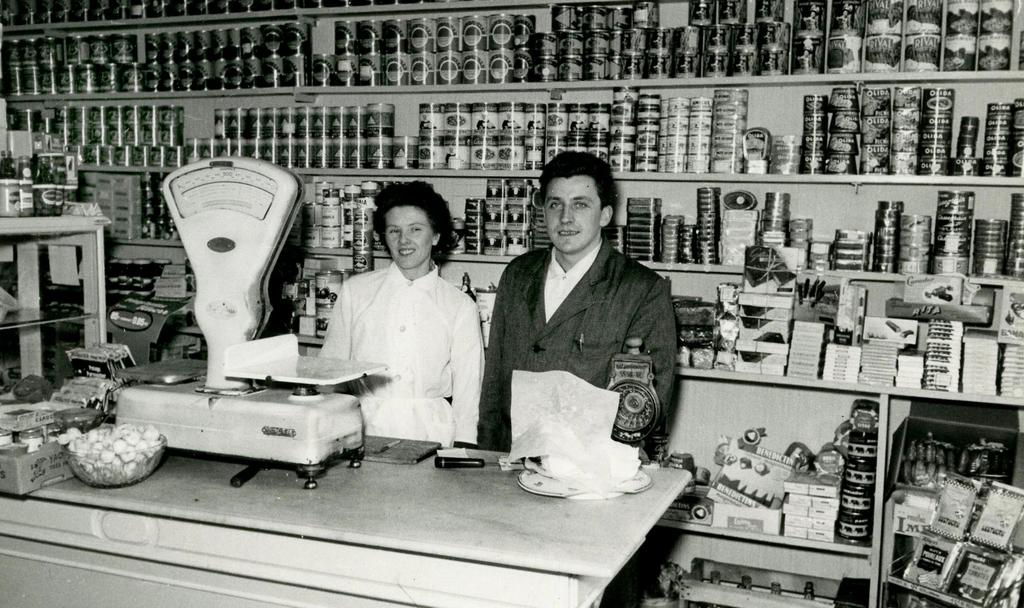 Kruidenierszaak, midden 20e eeuw, foto, coll. C.H.L. Met de ontwikkeling van de voedingsmiddelenindustrie verschijnen in de rekken van de kruidenierswinkels nieuwe producten in blik, fles of doos.