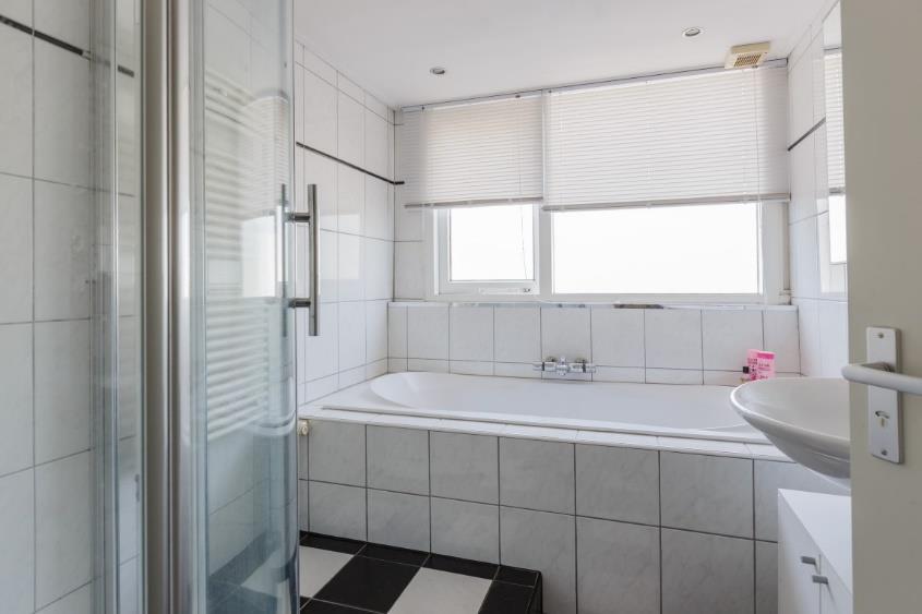 De badkamer: De badkamer is volledig betegeld en voorzien van twee grote ramen.