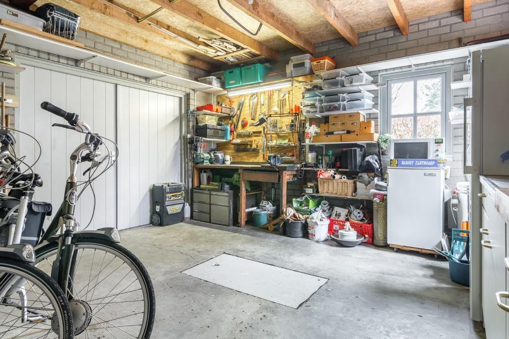 Garage/berging De inpandige garage/berging is voorzien van een houten werkbank (ter overname), krachtstroomaansluiting en een keukenblok met keukenkastjes.