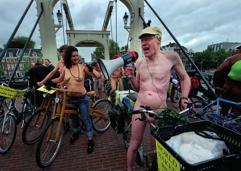 6 Naakte fietsers verzamelen zich bij de Magere Brug in Amsterdam om, ondanks het slechte weer, deel te nemen aan de negende editie van The World Naked Bike Ride; een demonstratieve optocht voor een