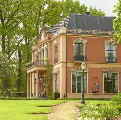 Het huis is witgepleisterd en heeft o.a. een bakkerij en een postkantoortje gehuisvest. Voor het huis staan twee leilinden. (GM) Dorpspand nr.