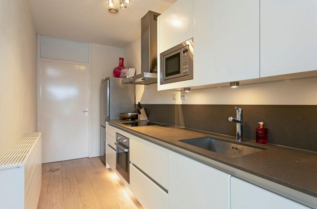 Ligging en indeling Keuken Moderne en strakke, open keuken met greeploos design en sfeervolle spotverlichting.