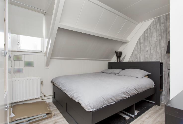 De master bedroom is afgewerkt met laminaat als vloerafwerking, behang als wandafwerking en schuurwerk als