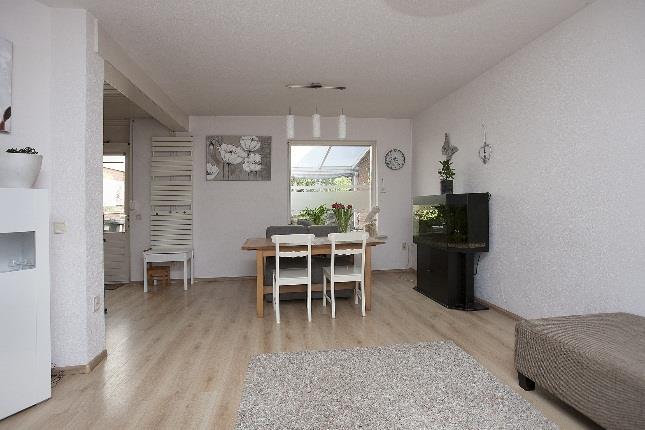 De woonkamer is modern uitgevoerd en voorzien van een mooie lichte laminaatvloer welke doorloopt in de keuken.