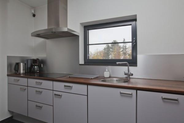 De praktisch ingedeelde woonkeuken is ingericht met een stijlvolle, moderne keukeninrichting in wandopstelling met