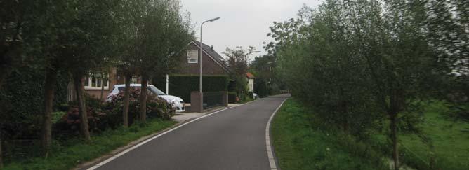 Hier en daar is een doorzicht naar het achtergelegen landschap. Op die plekken is het talud van de kade goed zichtbaar.