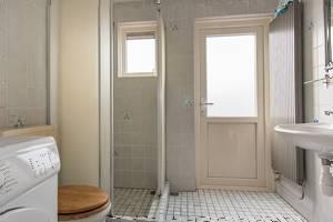 De badkamer is uitgevoerd in een lichte betegeling en is voorzien van een douchehoek, een toilet, een wastafel en aansluitingen voor huishoudelijk apparatuur.