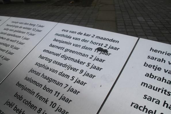 Naast de boom staat ook nog steeds een stuk van een hoge betonnen muur, die de trieste gebeurtenissen in de oorlog aan de ogen van de andere Rotterdammers onttrok.