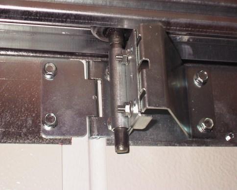 5) Montage van het poortblad: We plaatsen eerst het onderste paneel tussen de vertikale looprails. De brede rubberen afdichting staat langs onder. De metalen afsluitkappen naar binnen gericht.