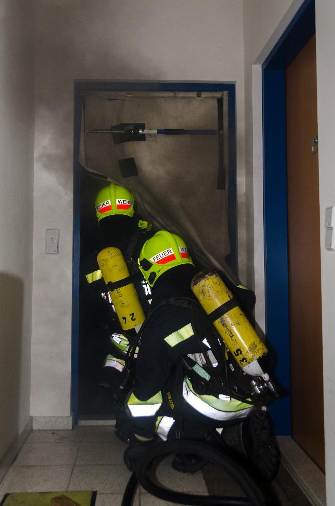 figuur 4 Bij deze brand heeft de ploeg een rookstopper geplaatst. Hierdoor wordt de uitstroom van rookgassen naar de gang beperkt.