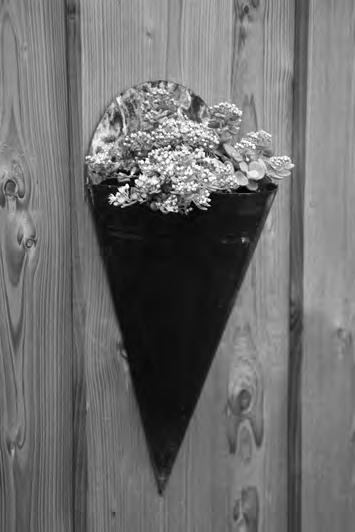 Bloembak Op de foto is een bloembak afgebeeld. De bloembak heeft de vorm van een (omgekeerde) halve kegel met boven aan de vlakke achterkant een extra halve cirkelschijf voor de bevestiging.